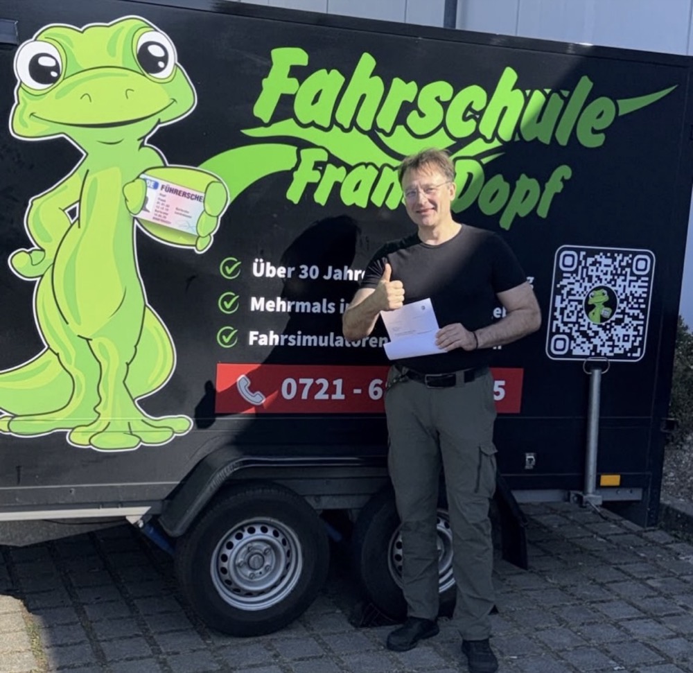 Fahrlehrer Frank Dopf vor dem Anhänger seiner Fahrschule