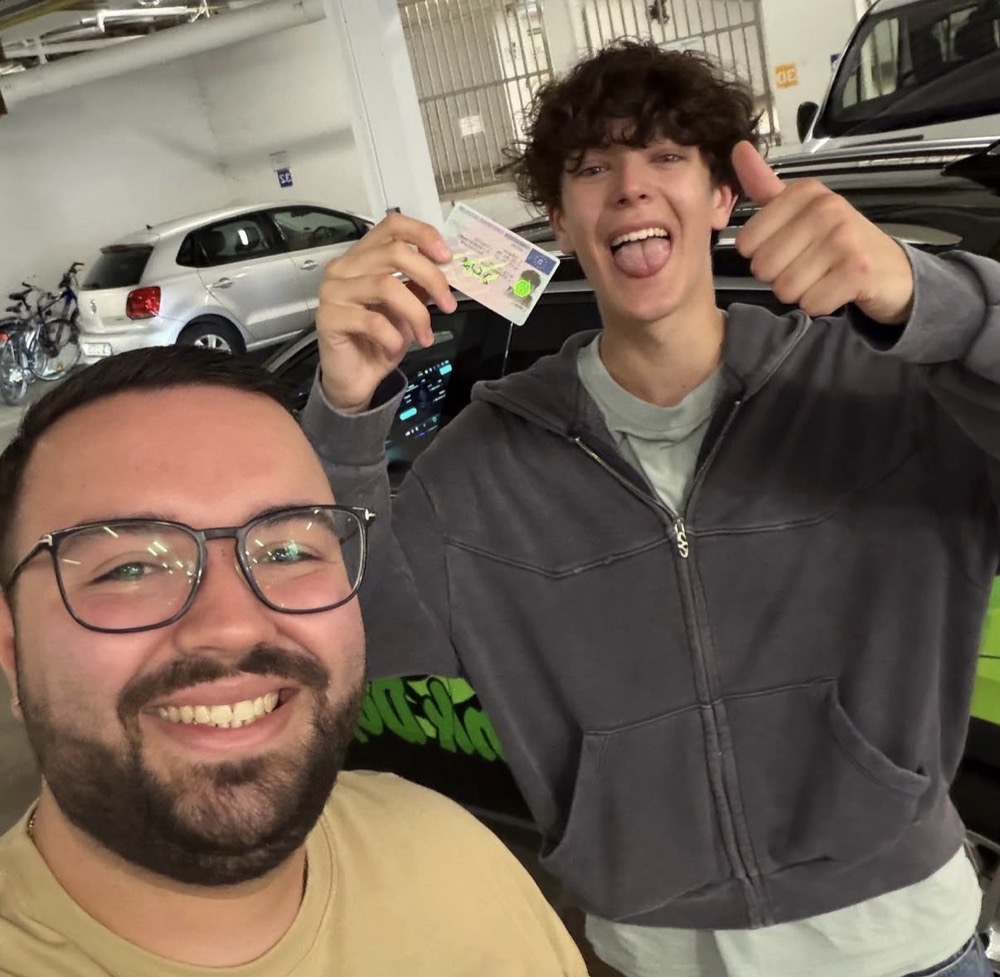 Selfie von Fahrlehrer und Fahrschüler mit frischem Führerschein